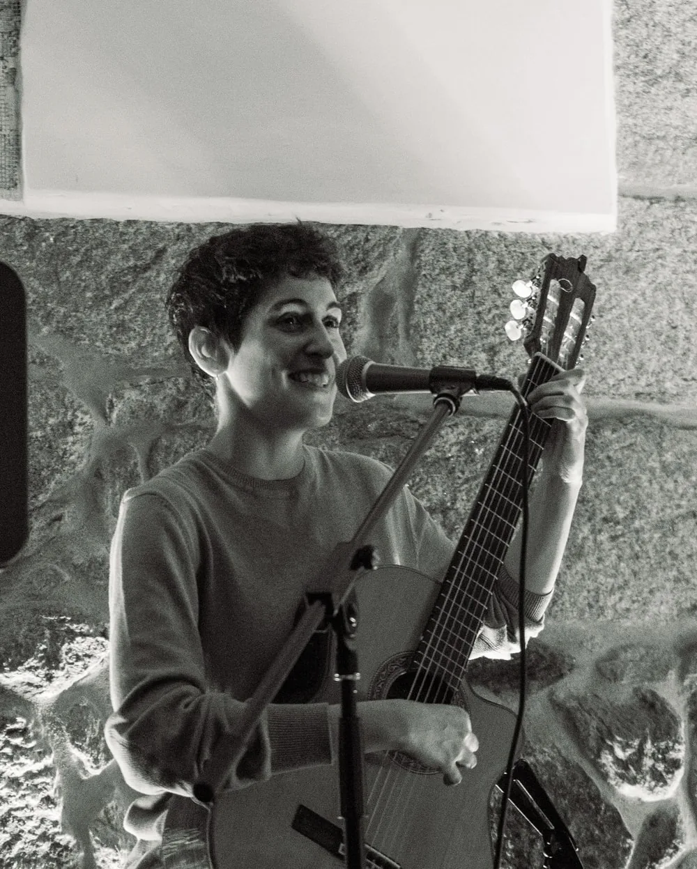 Retrato en blanco y negro de una cantante con guitarra durante una actuación